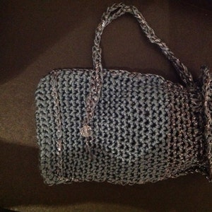 Grey crochet clutch with its strap extended, top view of the beaded evening bag.