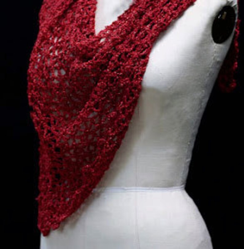 Red crochet shawl draped on a mannequin's torso, front view of the sparkling wrap.