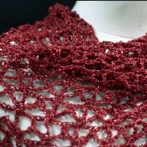 Close-up of the red lurex openwork, revealing the texture of the hand-crocheted stitches.