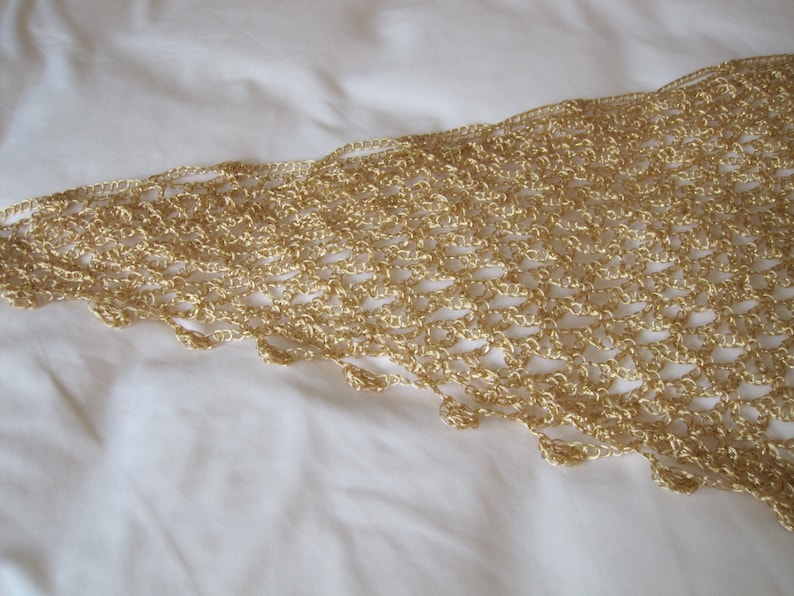 Close-up of the gold lurex crochet edge, revealing tight hand stitches and small beads along the scalloped trim.