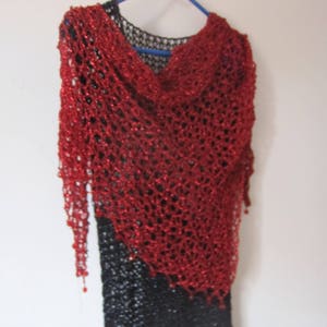Red lurex shawl on a black dress, alternate front view of the openwork wrap and beaded edging.