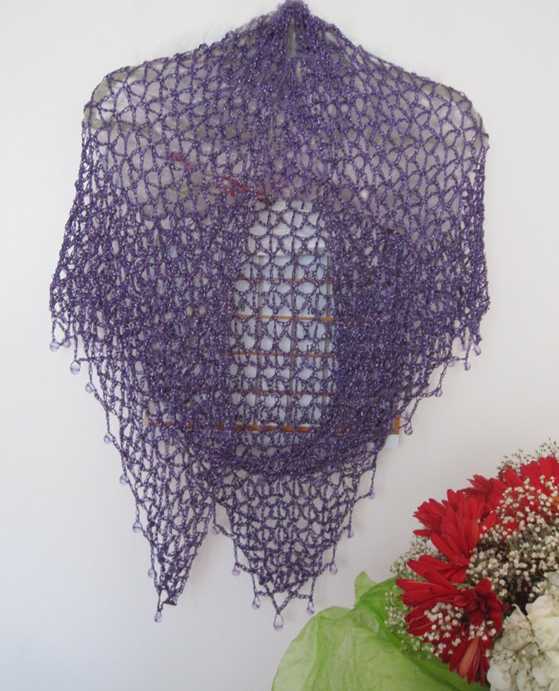 Purple lurex shawl centered in frame, front view of the even crochet and beaded hem.