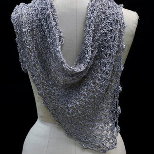 Back view of the silver-white bridal shawl on the mannequin, the wrap falling softly down the back.