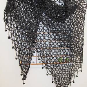 Black beaded crochet shawl hanging flat, full triangular view with beaded points along the hem.