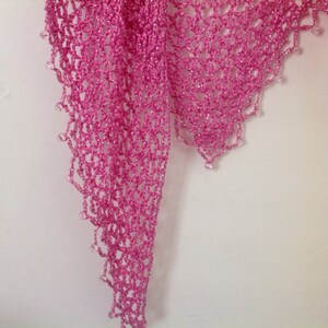 Close-up of the pink openwork crochet, showing the fine stitches and beaded edge.