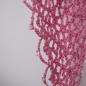 Close-up of the pink lurex crochet texture, glittering stitches in fine detail.