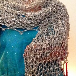 Silver shawl over a turquoise dress, closer view of the cowl neckline and openwork stitches.