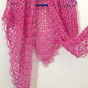 Pink shawl hanging with one end extended, showing how the lightweight crochet drapes.