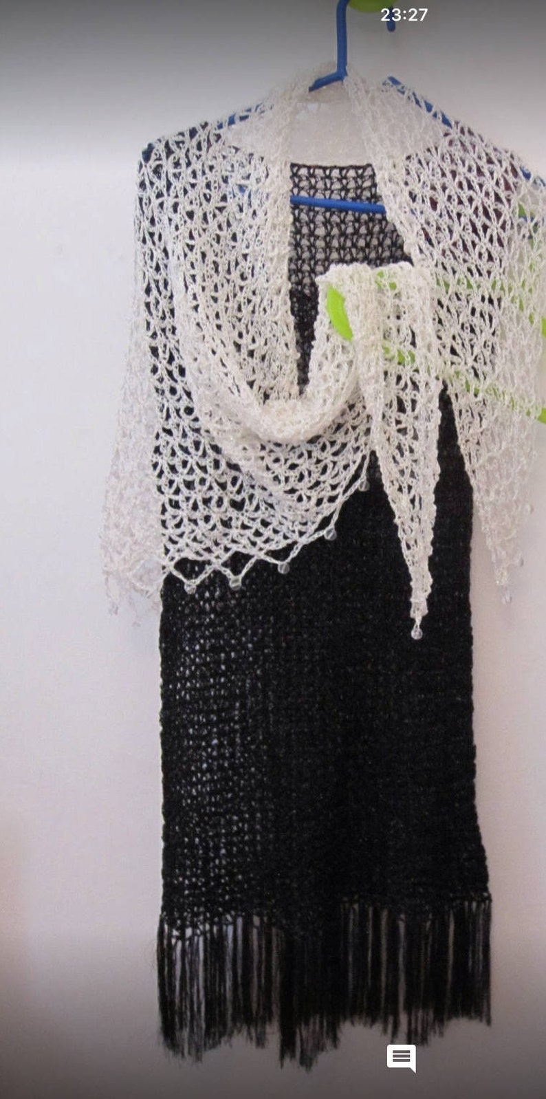 Cream shawl on a black dress, front view with the pointed hem falling center.