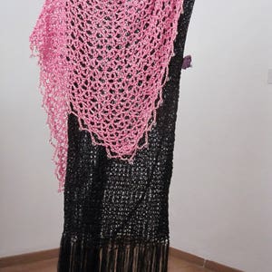Pink shawl draped over a black fringed dress on a stand, front view of the sparkling wrap.