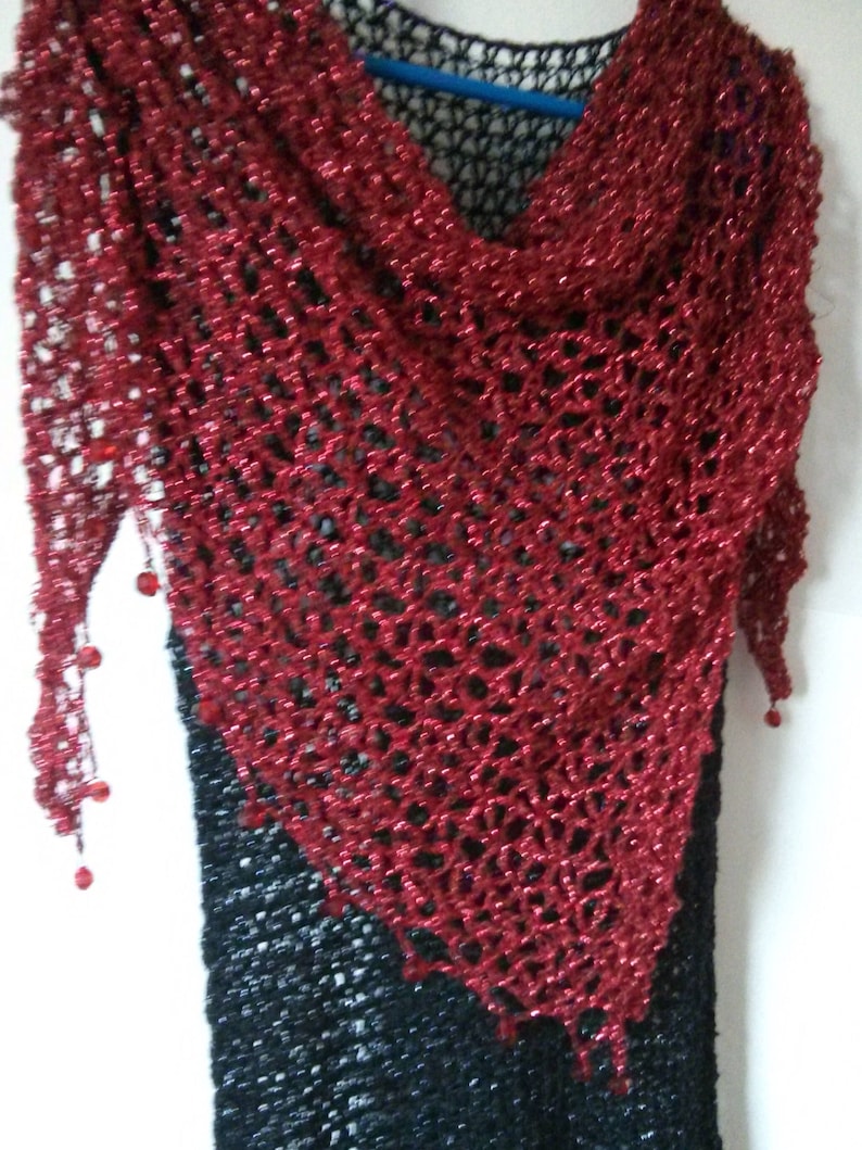 Front view of the red lurex shawl, showing the pointed hem, beaded trim, and dense sparkle of the weave.
