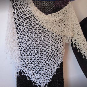 Close-up of the cream openwork crochet against the black dress, showing the fine stitch pattern.
