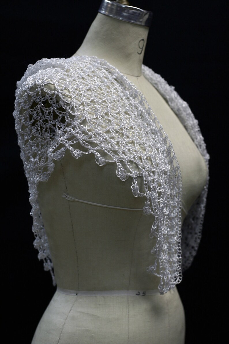 White shawl on the mannequin, alternate angle of the soft shoulder drape.