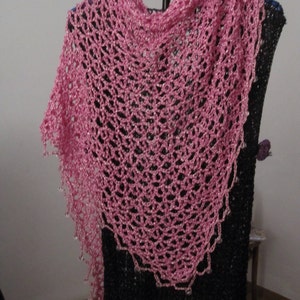 Pink lurex shawl on a hanger over a black dress, front view of the beaded openwork.