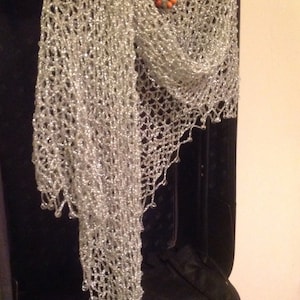 Silver beaded shawl over a dark garment with a beaded necklace, front view of the shimmering drape.