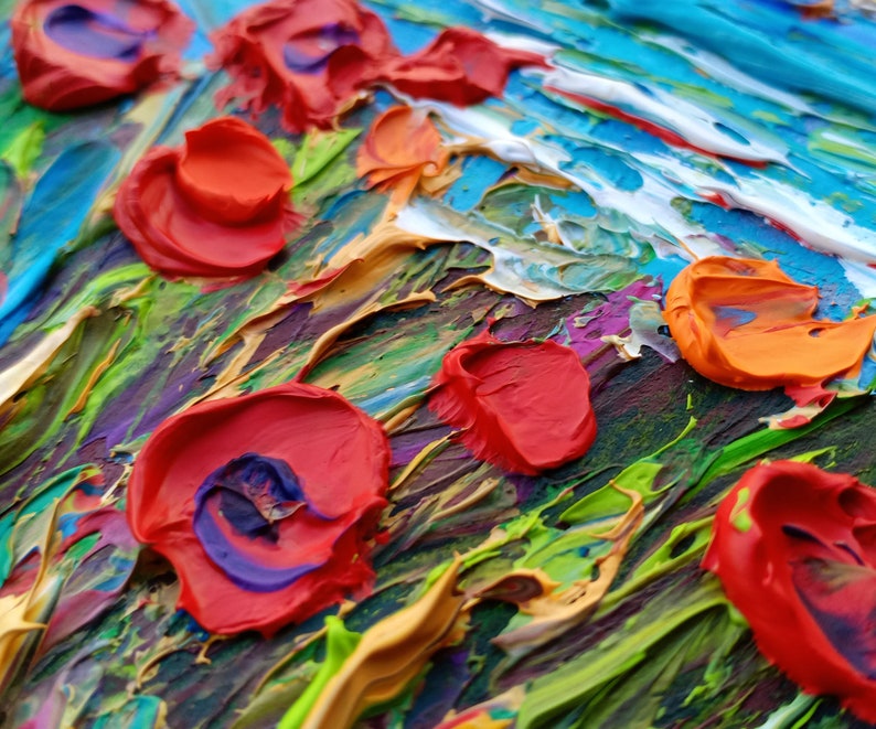 Puede incluir: Primer plano de una pintura abstracta con gruesas pinceladas. La obra presenta colores vibrantes rojo, naranja, azul, verde y morado. La superficie texturizada crea un efecto tridimensional, destacando las flores rojas.