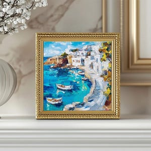 May include: A framed painting of a seascape with white buildings on a hillside overlooking a turquoise bay.  The painting is done in a loose, impressionistic style with visible brushstrokes.  There are several small boats in the water.