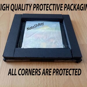 May include: A close-up of a painting protected by black foam padding. The foam is wrapped around the edges of the painting, and the text "NataShRay" is visible on the painting. The text "HIGH QUALITY PROTECTIVE PACKAGING" is at the top of the image, and the text "ALL CORNERS ARE PROTECTED" is at the bottom of the image.
