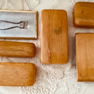 Könnte beinhalten: Sechs Holzkisten mit hellbrauner Oberfläche. Die Kisten sind alle rechteckig und haben eine glatte Oberfläche. Die Kisten sind in einer Reihe auf einer weißen Oberfläche angeordnet.