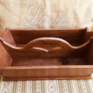 May include: A wooden tray with a carved handle. The tray is brown and has a rustic look. It is perfect for organizing small items.