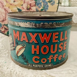 May include: Vintage Maxwell House Coffee tin. The teal can features red lettering and a coffee cup graphic. The words "ALL PURPOSE GRIND" and "ONE POUND" are also visible. The can is a classic piece of Americana.