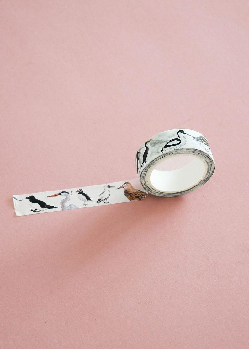 May include: A roll of white adhesive tape featuring a repeating pattern of various bird illustrations, including puffins, herons, and sandpipers in black, white, gray, and brown tones, with a portion of the tape unrolled to display the designs.