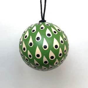 May include: A green Christmas ornament with a white and black teardrop pattern.