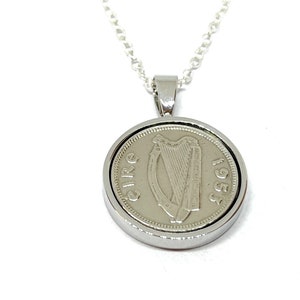 May include: Silver necklace with a round pendant featuring a 1953 Irish coin with the harp of Ireland and the word "Eire" on it.
