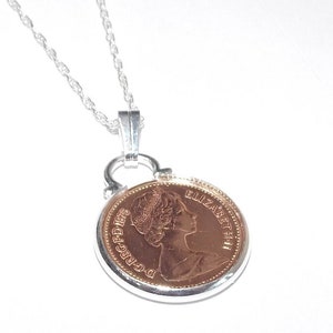 May include: A silver chain necklace with a pendant featuring a copper-colored coin with the inscription "D.G.REG.F.D. 1971" and "ELIZABETH II" on the obverse.