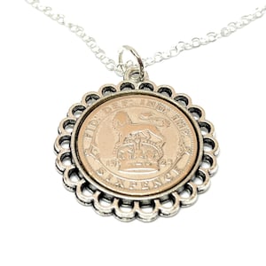 Peut inclure: Collier en argent avec un pendentif en argent représentant une pièce de six pence britannique de 1923 avec l'inscription "FID DEF IND IMP" et un lion. La pièce est entourée d'une bordure festonnée décorative.