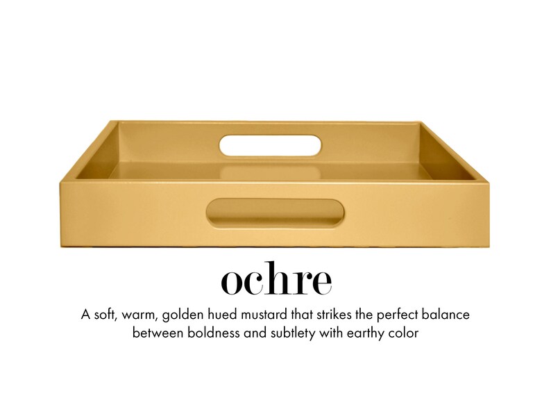 May include: A rectangular ochre tray with a smooth finish and two integrated cutout handles on the sides. Below the tray, the text reads: ochre. A soft, warm, golden hued mustard that strikes the perfect balance between boldness and subtlety with earthy color.