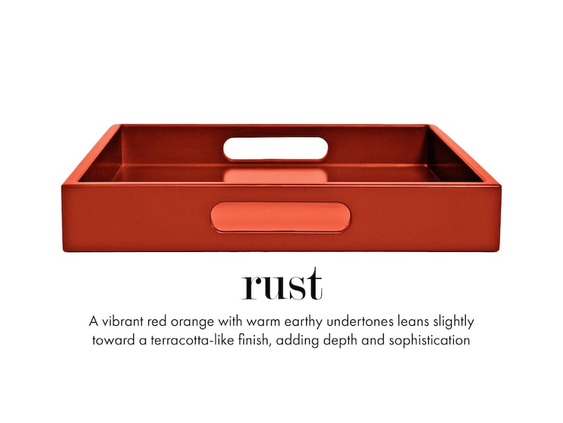 May include: A rectangular tray in a rust red-orange color with a smooth finish. The tray features integrated cutout handles on the sides. Below the tray, the text reads: rust. A vibrant red orange with warm earthy undertones leans slightly toward a terracotta-like finish, adding depth and sophistication.