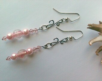 May include: A pair of dangle earrings with pink and clear glass beads and silver-toned metal hooks.