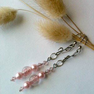 May include: Pink and clear glass bead earrings with silver chain and crystal accents.