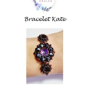 May include: A purple and black beaded bracelet with a large purple gemstone in the center. The bracelet is on a person's wrist. The text "Bracelet Kate" is visible above the bracelet.