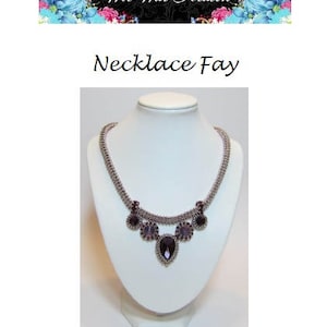 May include: A silver necklace with a purple crystal pendant and smaller purple crystals on the sides. The necklace is on a white mannequin bust.