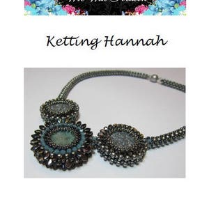 May include: A silver necklace with three round pendants. The pendants are made of silver beads and have a blue and gray color scheme. The necklace is called "Ketting Hannah".
