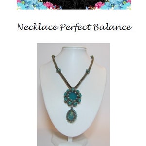 May include: A turquoise and silver beaded necklace with a teardrop pendant and a floral design. The necklace is displayed on a white mannequin bust.
