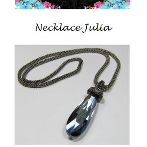 May include: A silver chain necklace with a teardrop-shaped blue crystal pendant. The pendant is attached to the chain with a silver knot.