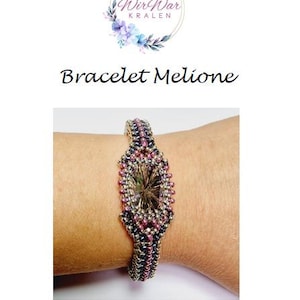 May include: A bracelet with a large, clear, faceted gemstone surrounded by small, purple and silver beads. The bracelet is on a person's wrist.