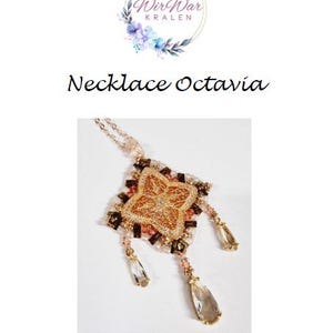May include: A gold necklace with a square pendant featuring a floral design. The pendant is surrounded by smaller beads in shades of brown, pink, and gold. The necklace has two crystal drops hanging from the bottom.