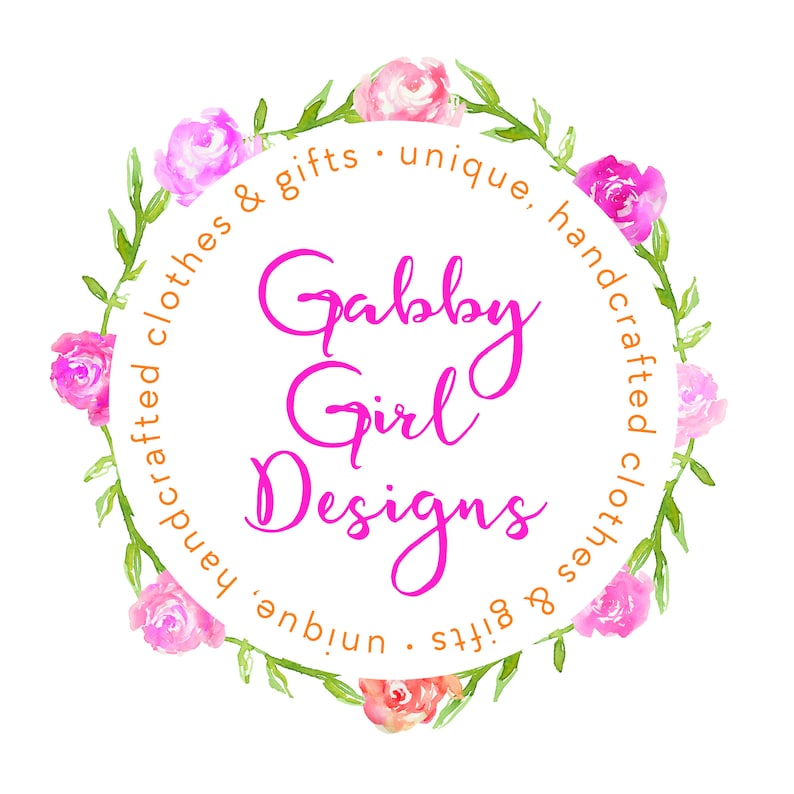 May include: A circular logo with the text "Gabby Girl Designs" in bright pink script. The text is surrounded by a wreath of watercolor pink roses and green leaves, with the words "handcrafted clothes & gifts &bull; unique" in orange.