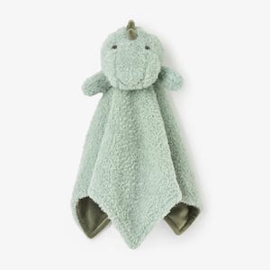 May include: A soft, mint green dinosaur-shaped baby security blanket. The plush toy has a textured body, small arms, and a smiling face. The blanket portion has a darker green trim and is designed for comfort and security.
