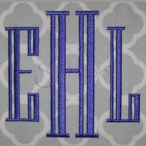 May include: Monogrammed design featuring the letters EHL in a bold, stylized font. The letters are a vibrant blue, embroidered on a light gray fabric with a repeating white quatrefoil pattern. The design is centered and stands out.