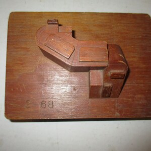 May include: A wooden mold with a complex, geometric design. The mold is mounted on a larger piece of wood with the number "2 68" inscribed on it.