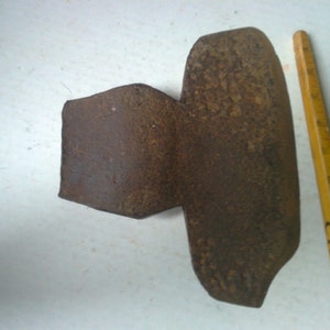 May include: A rusty metal tool with a curved blade and a flat handle. The tool is about 6 inches long and is sitting on a white surface.