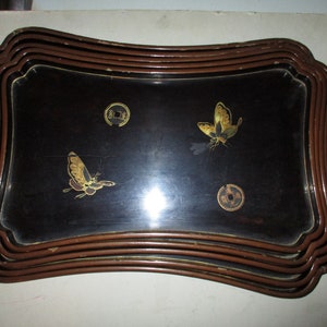 May include: Rectangular black serving tray with a decorative bamboo-style frame. The tray features gold-colored butterfly and coin designs. The frame is made of multiple layers of brown bamboo.