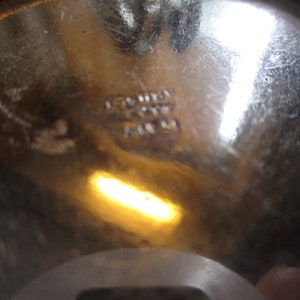 Op de afbeelding: Close-up van de bodem van een zilveren metalen kom met de tekst "Stainless Steel Made in USA" gestempeld op de bodem.