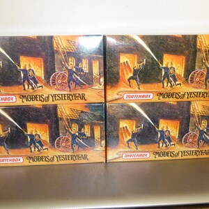 May include: Four Matchbox Models of Yesteryear boxes. Each box features a vintage illustration of firefighters battling a blaze, with the text "MATCHBOX MODELS of YESTERYEAR". The boxes are stacked on top of each other.