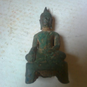 May include: A small, green bronze statue of a seated Buddha. The statue has a serene expression and is wearing a robe.